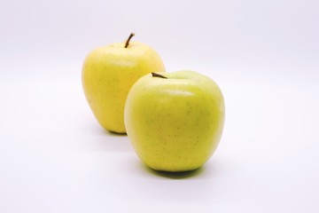Two yellow apples on white background