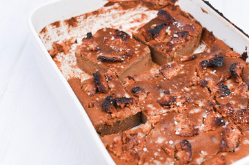 Chocolate cake with salt and caramel cookies on a white background. Traditional American dessert cut into portions. Free space for text. Copy space.