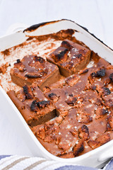 Chocolate cake with salt and caramel cookies on a white background. Traditional American dessert cut into portions. Free space for text. Copy space.