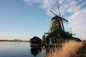 Fototapeta na wymiar old dutch wooden windmill in zaanse schans on the water of the river Zaan