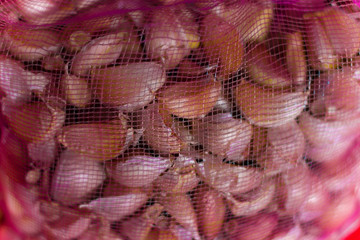 Pile of fresh Thai garlic in net mesh bags for wholesale market, Garlic in net bag, in the shop for sale