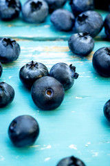 Frische Bio Heidelbeeren auf blauem Holz, Vaccinium myrtillus