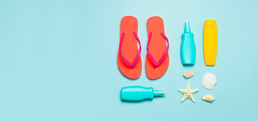 Summer beach sea accessories. Coral flip flops, shells, starfish, yellow sunscreen bottle, body...