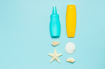 Summer concept, marine background. Seashells, starfish, sunscreen body cream spray on pastel blue background. Top view, flat lay, copy space. Sea summer vacation Mockup. Travel, marine souvenir