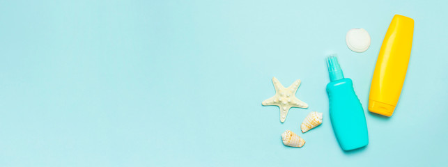 Summer concept, marine background. Seashells, starfish, sunscreen body cream spray on pastel blue background. Top view, flat lay, copy space. Sea summer vacation Mockup. Travel, marine souvenir