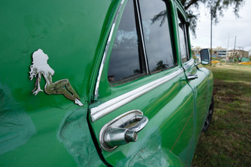 Chrom decoration, in form of a naked lady, on the side of a classic green vintage American car in Varadero, Cuba