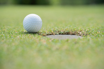 Close up golf ball on lip of cup in course - Image