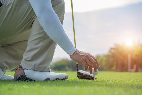 Man hand putting golf ball on tee in golf course - Image