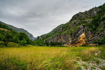 Montenegro, Green meadow in moraca canyon nature landscape surrounded by huge mountains