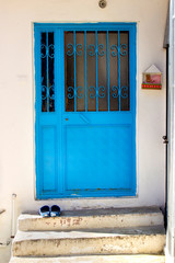 blue door, blue slippers and white wall