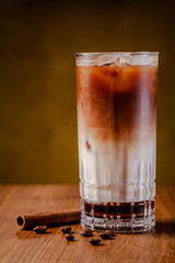 Iced coffee with ice. Frappe, frappuccino with cream and cinnamon on a wooden table. copy space