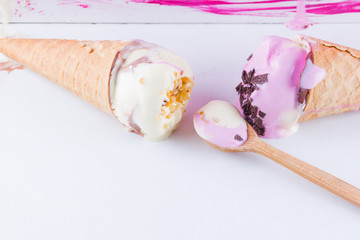Melted ice cream on a pink white background. Two ice cream cones in pop art style. Summer milk dessert with wooden spoon. Summer concept
