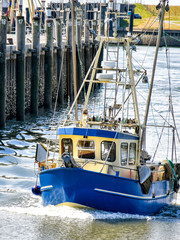 A small fishing boat enters the harbour of Büsum in North Frisia in Germany.