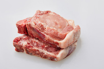 Raw pork loin isolated on white background. Raw fresh pork fillet steak with the bone. Sliced raw...