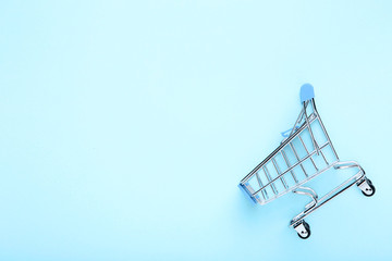 Small shopping cart on blue background