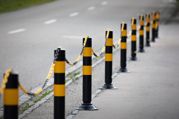 Gelbschwarze Absperrung am Strassenrand, tiefenunschärfe