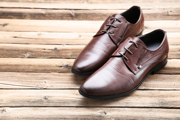 Male leather shoes on brown wooden table