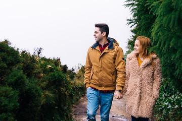 the couple in love in warm jackets hold hands and climb the path