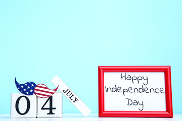 Text Happy Independence Day with cube calendar and paper mustache on blue background