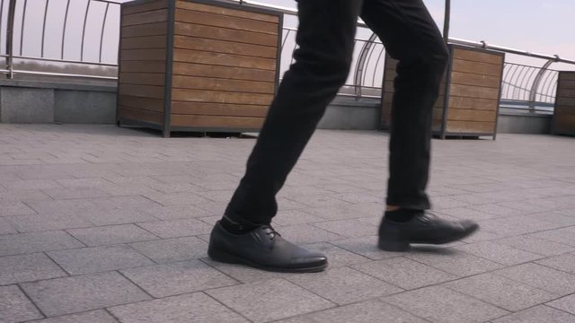 Closeup shoot of male legs doing an amazing footwork and dancing on the street outdoors in the city