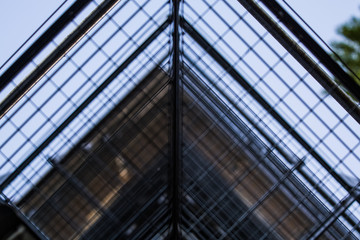 Background or texture in the blue sky of a crossbeam from building lattices. View of balconies from below. Cage, grid, wire.