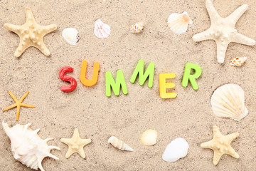 Word Summer with seashells on beach sand