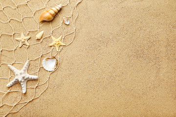 Seashells with fishing net on beach sand