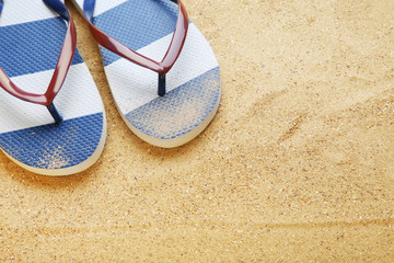 Fototapeta na wymiar Blue flip flops on beach sand