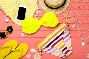 Fashion swimsuit and clothing with seashells on wooden table