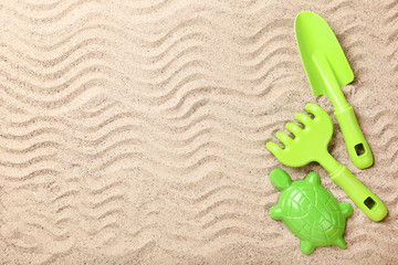 Fototapeta na wymiar Plastic toys on beach sand