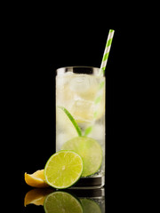 Citrus summer cold coctail or lemonad with ice on black background. Studio shot. Alcohol tasty drink.