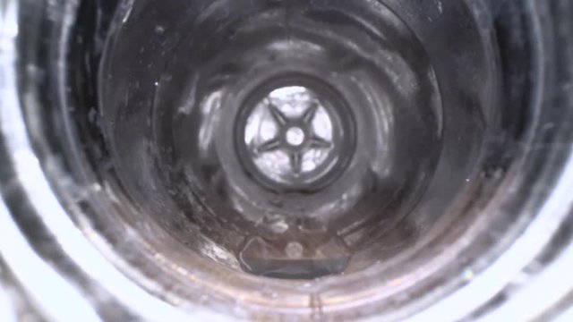 Inside the plastic bottle. Dolly macro shot of camera zooming in empty water bottle on wooden background