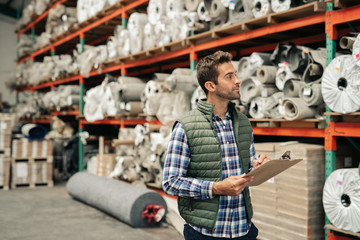 Worker doing an inventory check on a warehouse floor