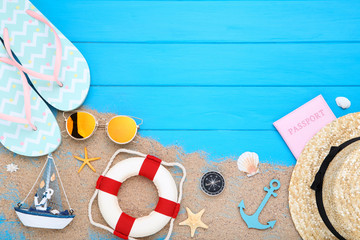 Fashion clothing with seashells and lifebuoy on blue wooden table