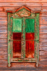 Weathered wooden window in slums painted in green and red