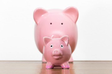 Large and small pink piggy banks representing parent with child.  