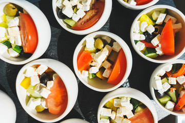 Salad and light meals, canapes on the table in the restaurant.