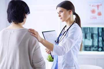 Medical consultation. Female doctor holding a patient by her shoulder, soothing her fear