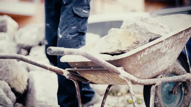 Loading big rocks in to wheelbarrow