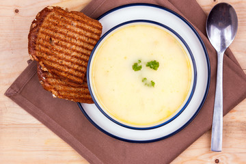 Cheese soup in a white plate with toasted bread