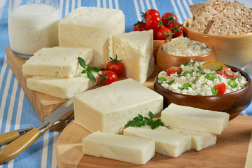 cheeses group,cheeses cut on the chopping board, curd cheese in wooden container