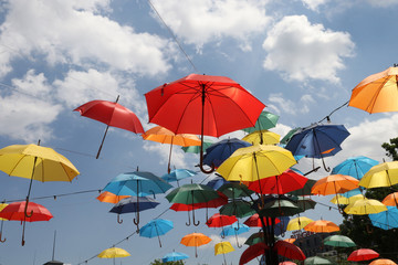 Multicolored umbrellas. Colorful umbrellas flying in the summer blue sky.