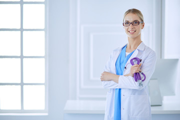 Cheerful happy doctor with crossed hands on blue background