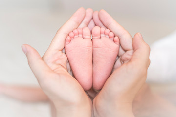 Obraz na płótnie Canvas Close up of newborn baby feet on female hands
