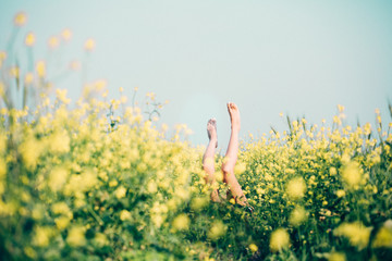 Woman laying down green field with legs up