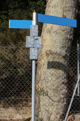 Blaue Straßenschilder an einer Metallstange