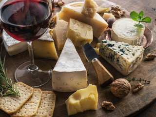 Cheese platter with organic cheeses, fruits, nuts and wine. Tasty cheese starter.