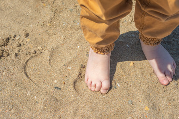 bare children's feet on the beach. close-up