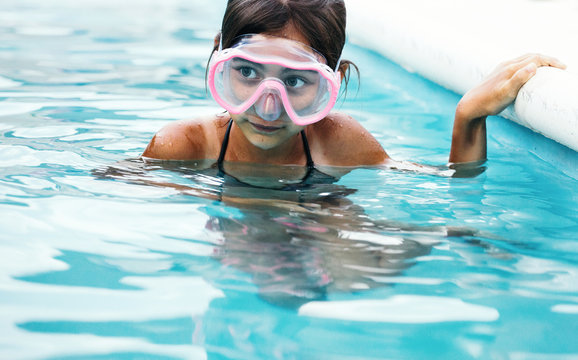 Little Girl In Swimming Pool Wearing Goggles