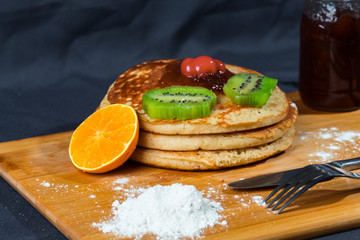 Hot cakes cubiertos de mermelada y kiwis